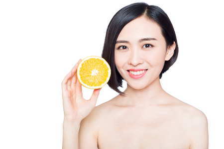 young woman with oranges in her hands, white backgroundの写真素材