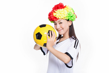 beautiful cheerleader holding yellow soccer ball on a white backgroundの写真素材