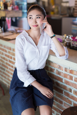 Young woman talking on her mobile phone in barの写真素材