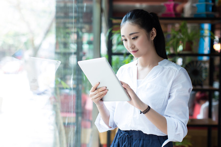 Young women using her tablet in a cafe