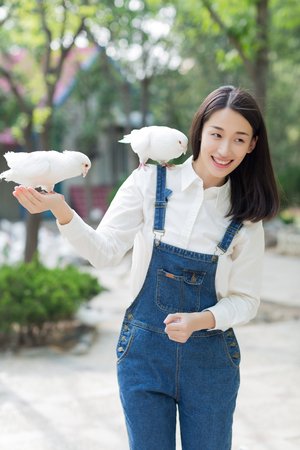smiling girl with pigeons on the arm, asian womanの写真素材