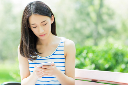 girl playing with her phoneの写真素材