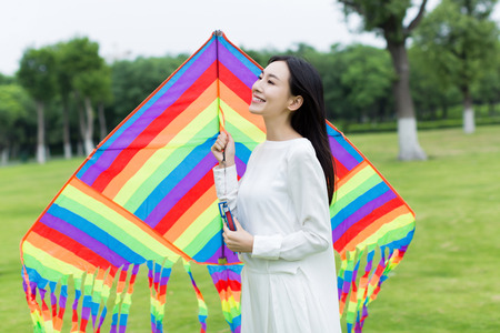 cute chinese girl flying a kite in the parkの写真素材