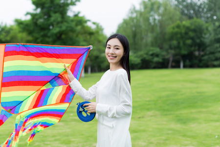 chinese girl flying a kite in the parkの写真素材