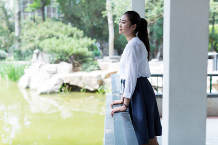 chinese girl standing alone in the park pavilion aroundの写真素材