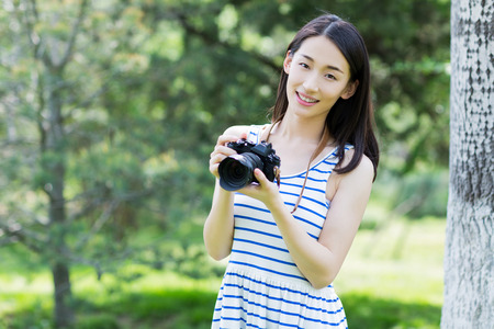 chinese girl taking photo with the cameraの写真素材
