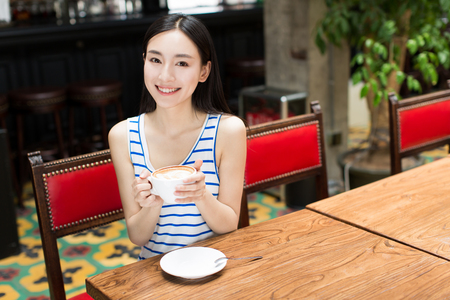  young girl with cup of coffee on brown backgroundの写真素材