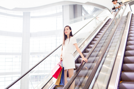stylish girl holding shopping bags at the mallの写真素材