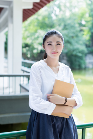 Girl in a park holding a bookの写真素材