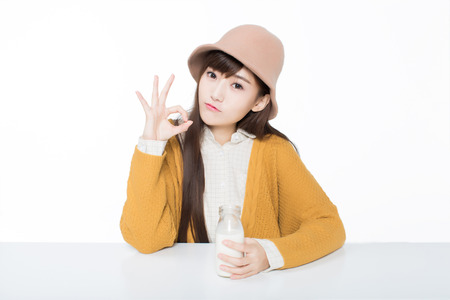 girl sitting in a classroom, with holding a milk.の写真素材