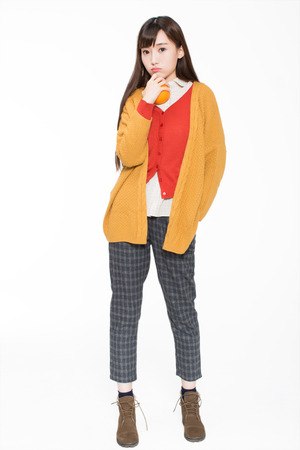 pretty chinese girl, she holding an orange in the room. In the white backgroundの写真素材