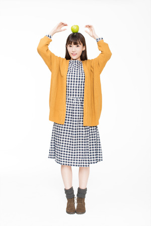 cute girl holding a green apple, on white background in studio.の写真素材