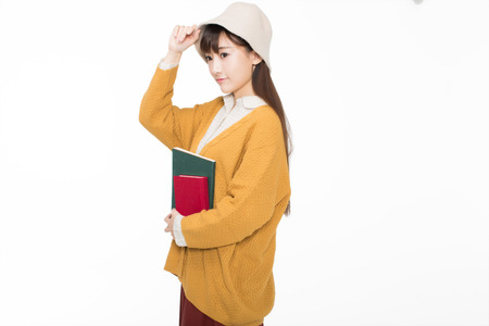 cute chinese female students in the classroom holding books read.の写真素材