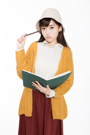 cute chinese female students in the classroom holding books read.の写真素材