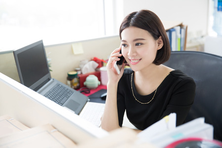 young beautiful girl, sitting in the office began her workの写真素材