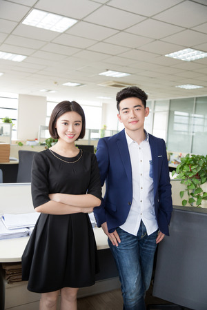 chinese young handsome boss talking to his assistant at workの写真素材