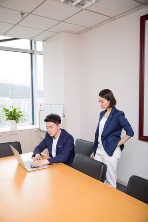 chinese young handsome boss talking to his assistant at workの写真素材