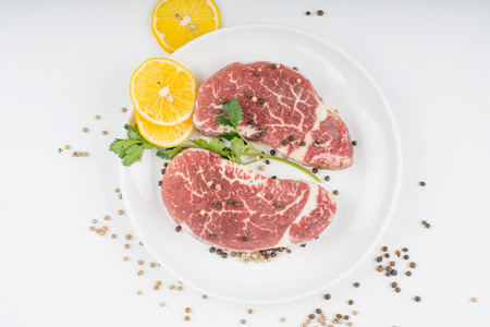 raw steak and spices on plate. Isolated on white backgroundの写真素材