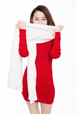 Shy woman holding white scarf covering her mouth on white background.の写真素材