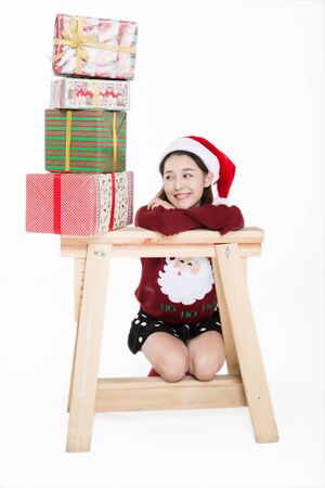 Young woman with stacked of christmas gifts on white background.の写真素材