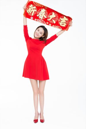 Beautiful girl holding up couplet celebrates Chinese new yearの写真素材