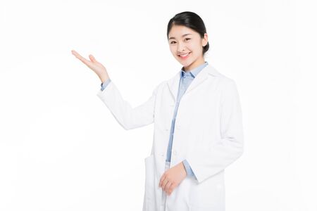 Young woman wearing a surgical gown and showing hand gestureの写真素材