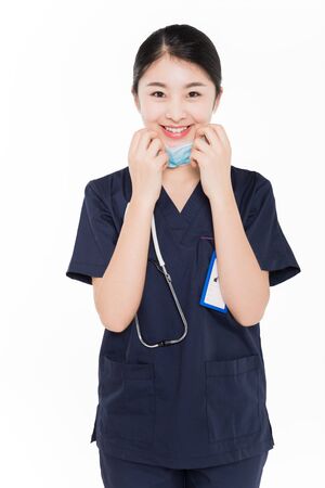 Female surgeon removing surgical maskの写真素材