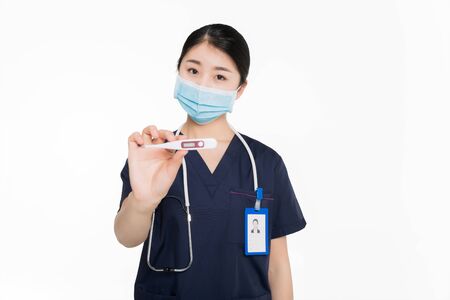 Female surgeon with surgical mask showing a thermometerの写真素材