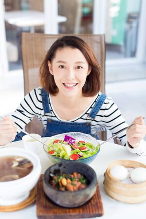 happy woman eating out in a restaurant,China.の写真素材