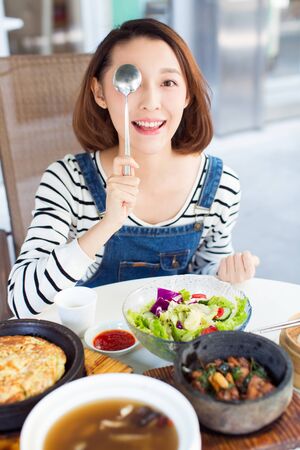 happy woman eating out in a restaurant,China.の写真素材