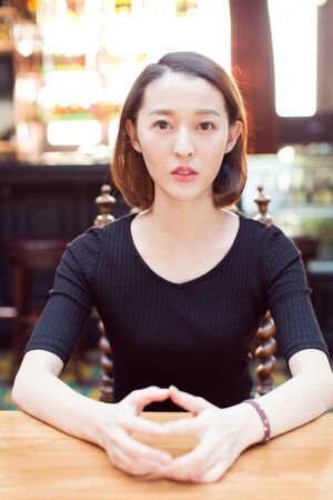 young woman taking a break at cafe,or is waiting someone.の写真素材