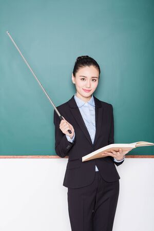 portrait of female teacher pointing to chalkboard, chinese, asia.の写真素材