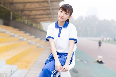 girl wearing a blue T-shirt uniforms at the campus playgroundの写真素材