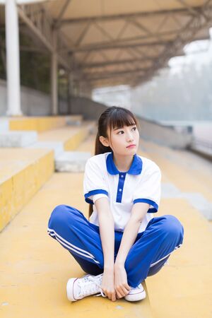 girl wearing a blue T-shirt uniforms at the campus playgroundの写真素材