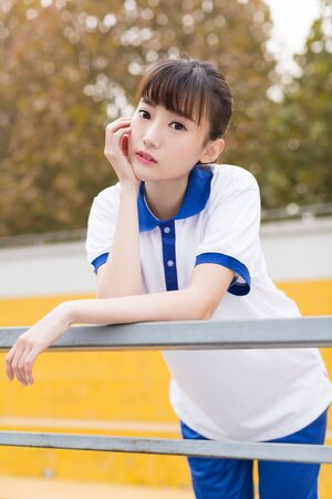 girl wearing a blue T-shirt uniforms at the campus playgroundの写真素材