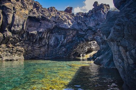 Swimming natural pools of volcanic lava in Seixal, Madeira island, Portugal, Europe. There is beautiful view on sea cliffs and waves of Atlantic ocean. It is summer.の写真素材