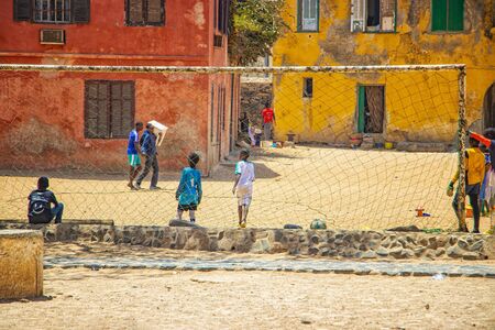 Goree island, Senegal- April 22 2019: Unidentified boys play soccer on the sand in the town in...