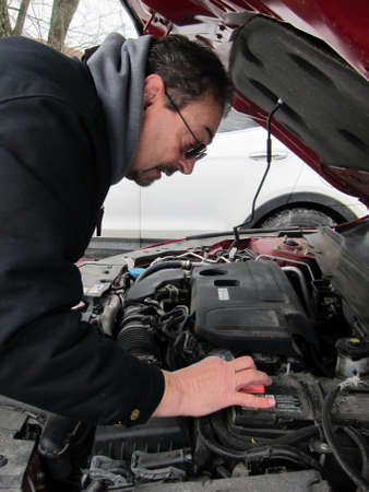 Senior man working on his carの写真素材