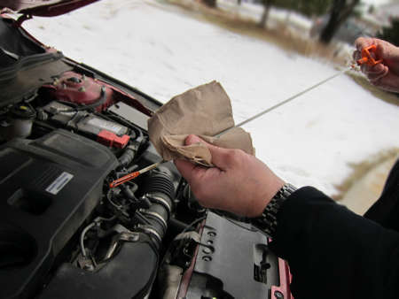 a man checking oil in carの写真素材