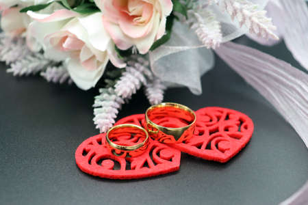 Felt hearts with wedding rings and bridal bouquetの写真素材