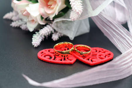 Felt hearts with wedding rings and bridal bouquetの写真素材