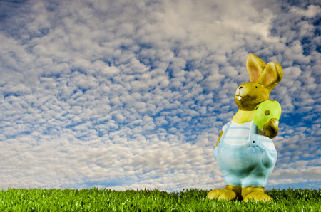 Easter bunny with eggs between sky and grass. horizontal for easterの写真素材