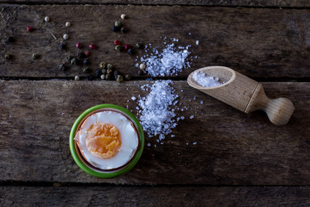 boiled egg and salt on a wooden tableの写真素材