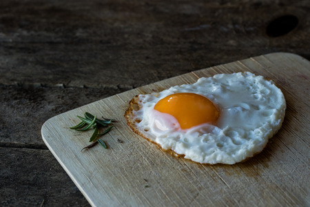 fried egg on a board, black backgroundsの写真素材