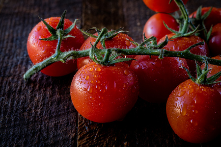 Wet tomatoes on an old tableの写真素材