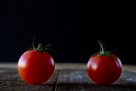 Wet tomatoes on an old tableの写真素材