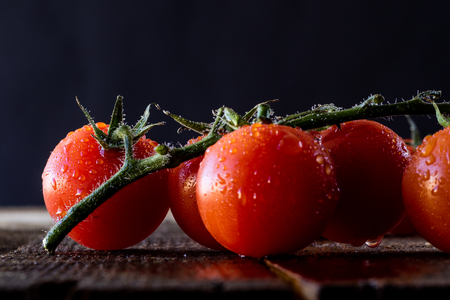 Wet tomatoes on an old tableの写真素材
