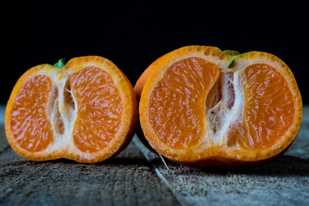 Strawberries and tangerines on an old wooden table in an old kitchen, black backgroundの写真素材