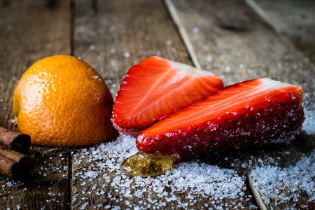 Mandarin, strawberry and chocolate on an old wooden table in an old kitchen on a black backgroundの写真素材