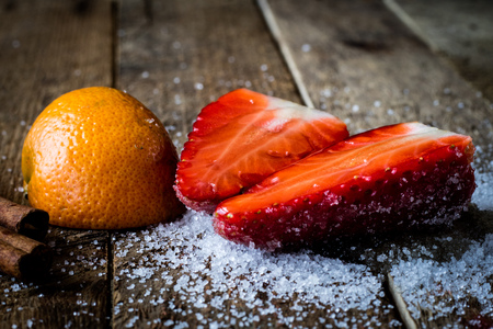 Mandarin, strawberry and chocolate on an old wooden table in an old kitchen on a black backgroundの写真素材